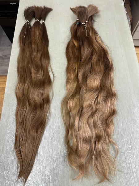 Two bundles of hair used for Florence Pugh's two wigs on the table next to each other.